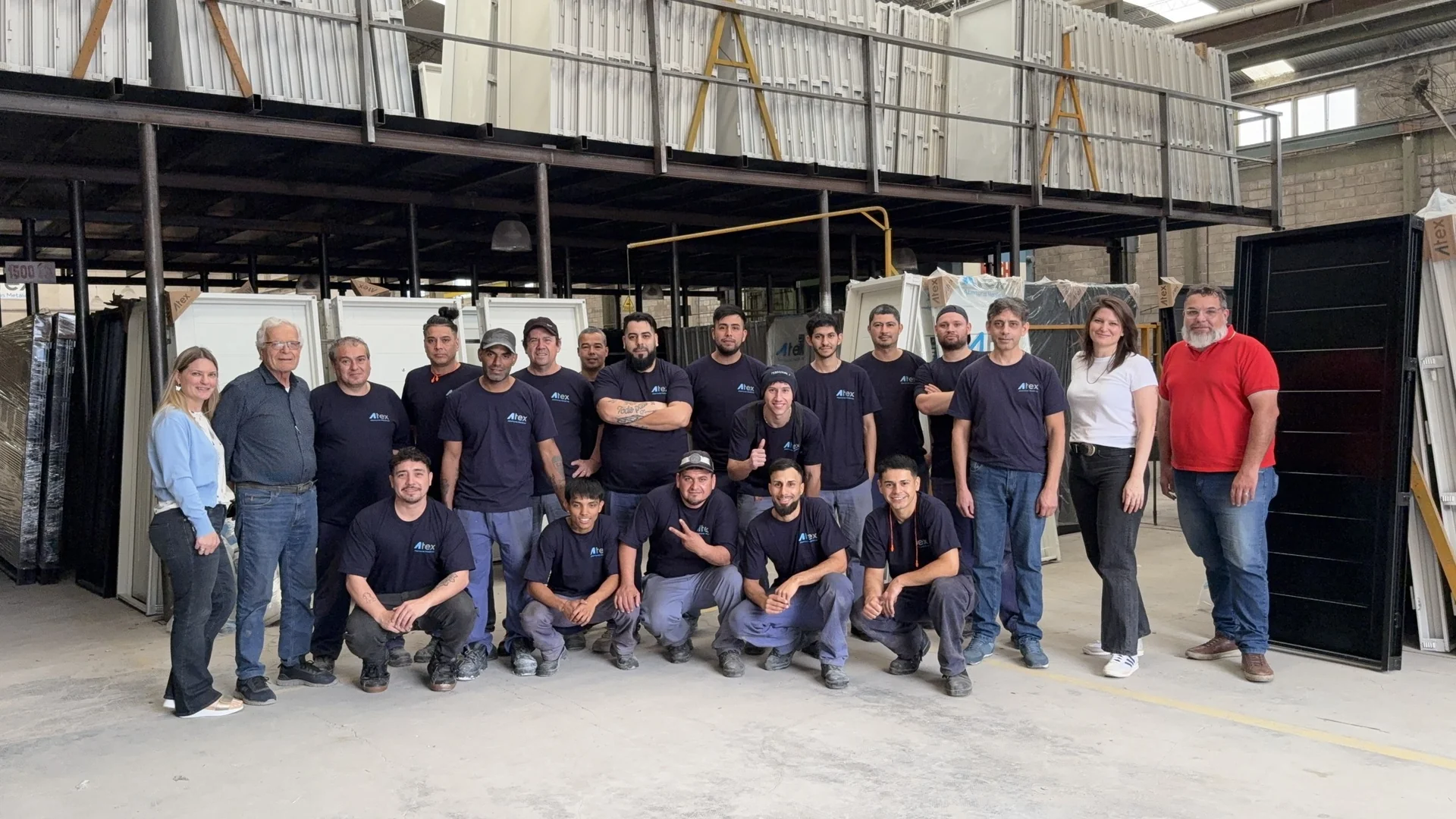 Equipo de Atex reunido dentro de la fábrica frente a aberturas metálicas.