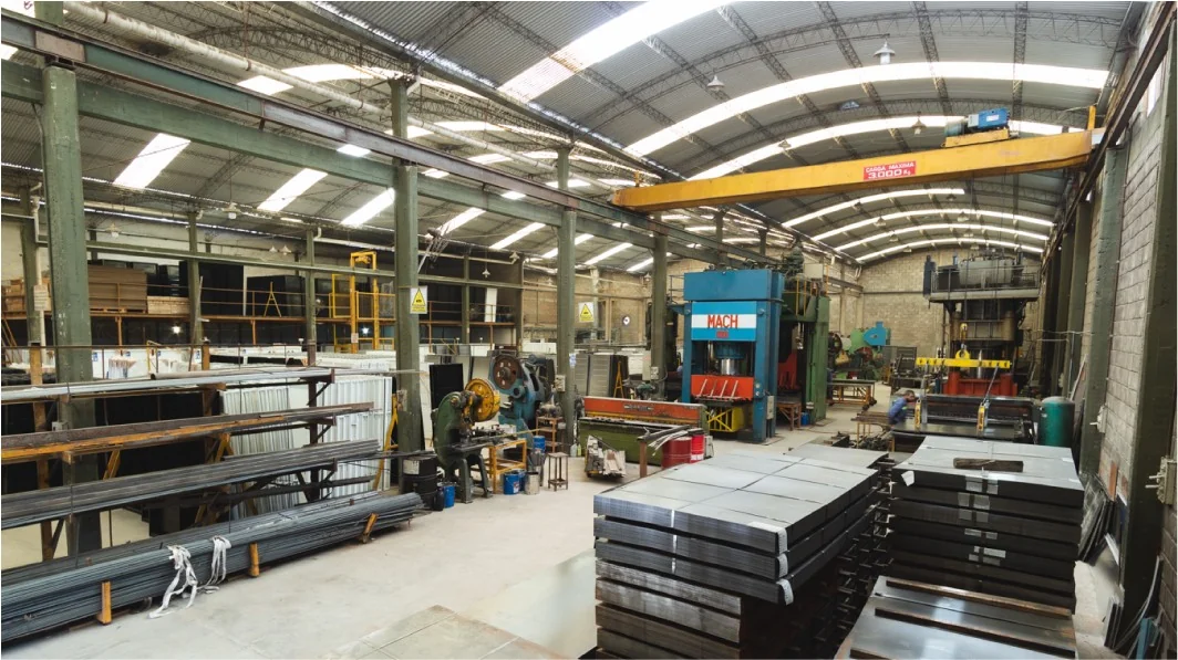 Vista interior de la planta de Atex con sectores de trabajo y aberturas metálicas en fabricación.